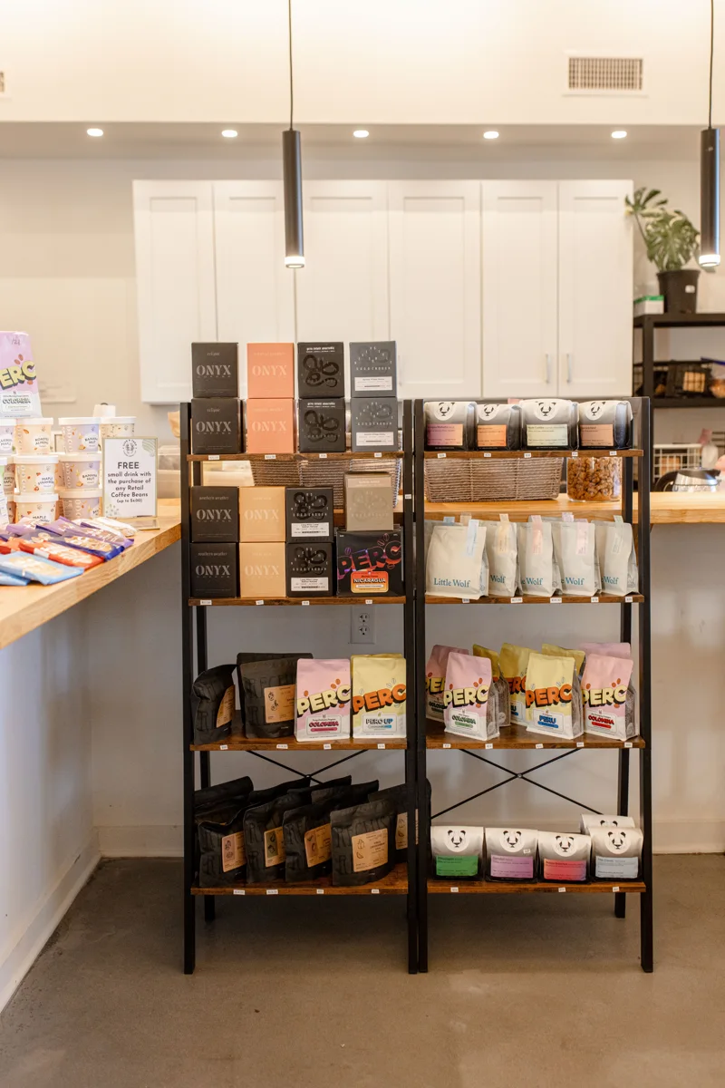 Bags of coffee and drinks on the retail shelf beside the counter